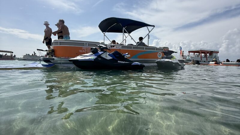 jet ski and pontoon boat sitting at crab island in destin fl